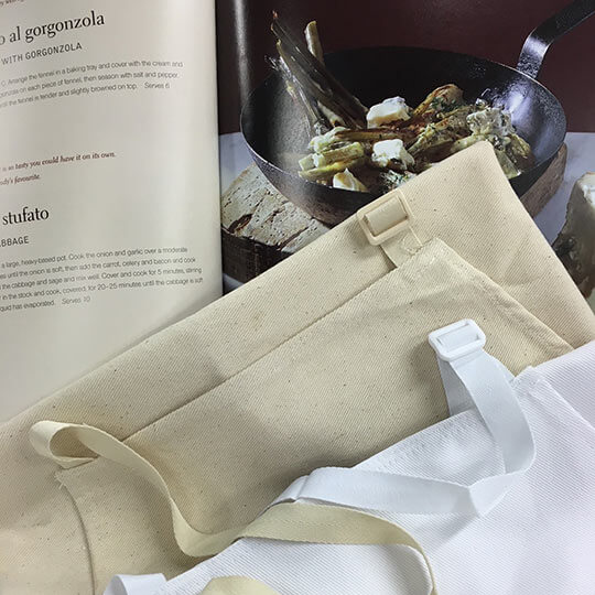 Aprons folded in the kitchen with a recipe.